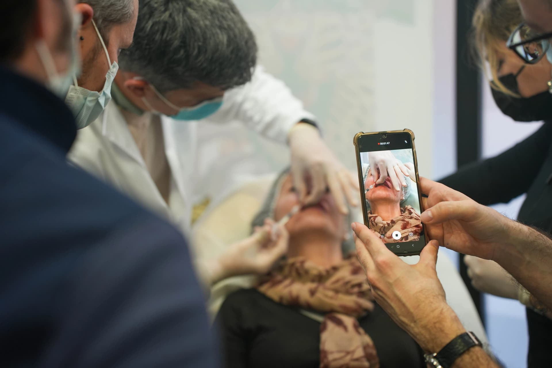 Dentistas grabando una demostración de infiltración de ácido hialurónico en curso práctico de Bintal